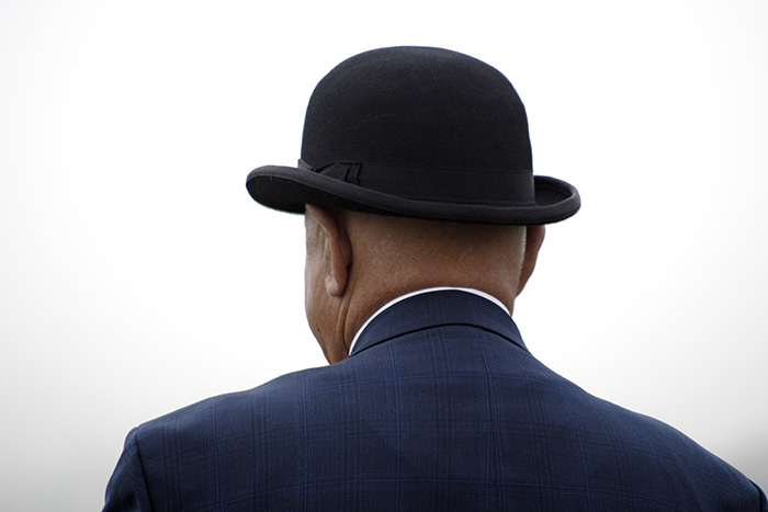 Candid image of an elderly man in a bowler hat photographed from behind
