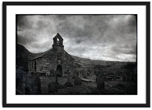 An aged image of Eglwys Sant Mihangel, against a menacing sky in Cwm Pennant, Wales