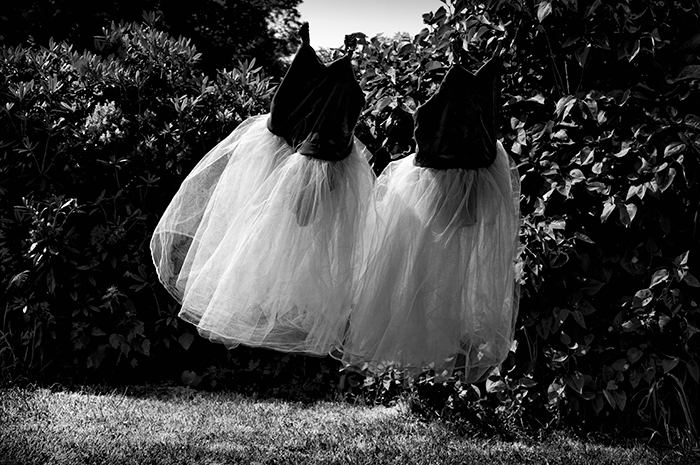 Two party dresses floating through the air in a garden