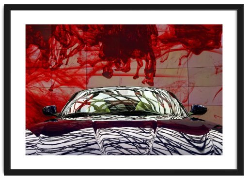 Framed image of a low front view of a sports car against a giant plasma screen showing a moving pattern of red blood