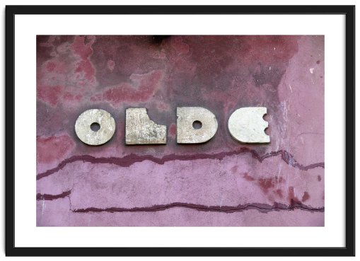 Framed image of a decaying pink wall embossed in white with the word 'OLDE'
